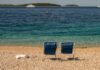 Dwa puste krzesła na plaży w Primošten nad krystaliczną wodą