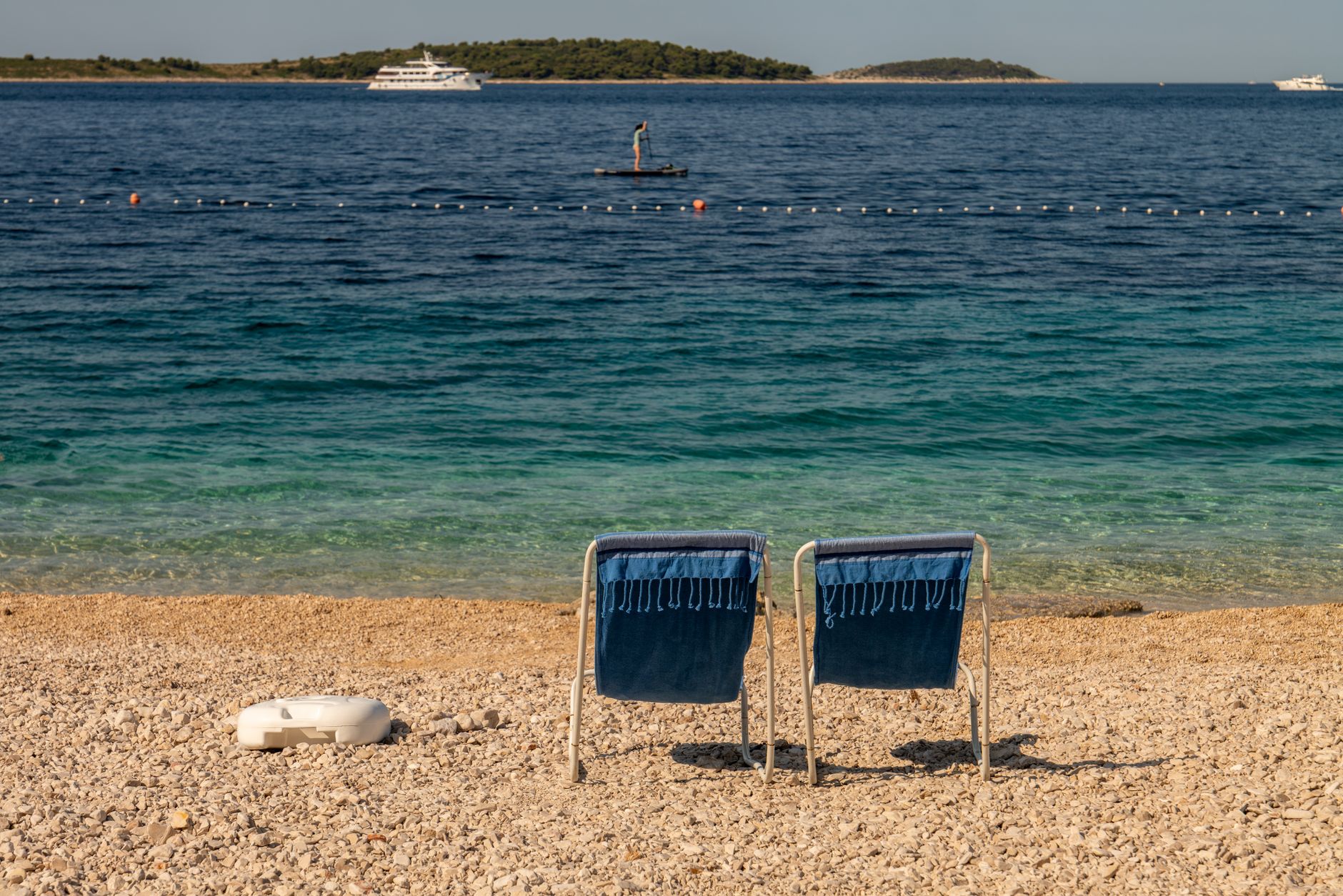 Dwa puste krzesła na plaży w Primošten nad krystaliczną wodą Dwa puste krzesła na plaży w Primošten nad krystaliczną wodą